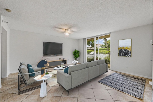 living room featuring light tile patterned floors, a textured ceiling, and ceiling fan