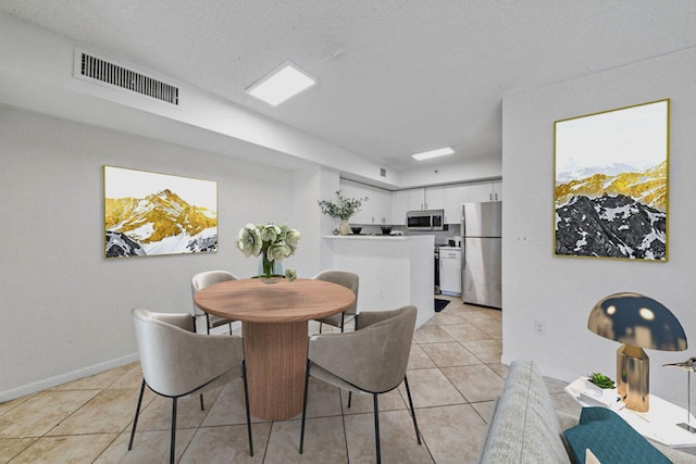 tiled dining area featuring a textured ceiling