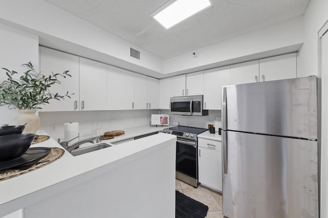 kitchen featuring white cabinetry, a sink, visible vents, stainless steel appliances, and light countertops