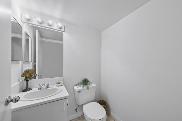 half bath with vanity, toilet, and baseboards