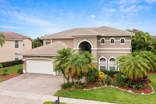 mediterranean / spanish home featuring a front yard and a garage