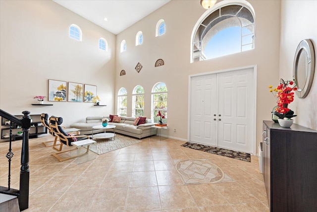 entrance foyer featuring light tile patterned flooring and a towering ceiling