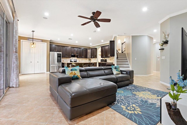 living room featuring light tile patterned floors, ornamental molding, and ceiling fan