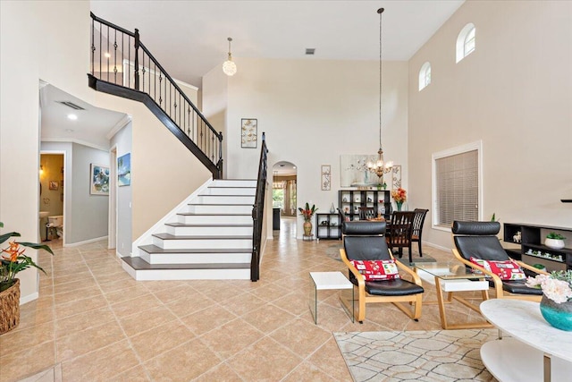 interior space with a high ceiling, a notable chandelier, and light tile patterned floors