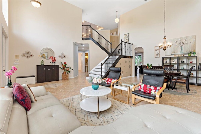 living room with a high ceiling, light tile patterned floors, and a notable chandelier