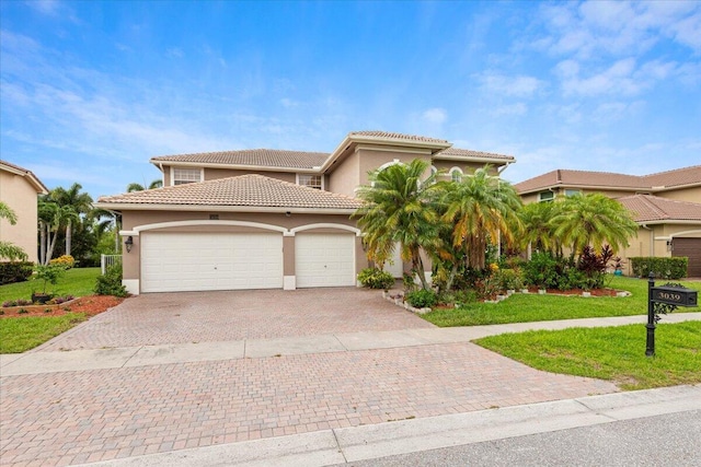 mediterranean / spanish home featuring a front yard and a garage