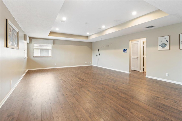 unfurnished room featuring dark hardwood / wood-style flooring and a raised ceiling