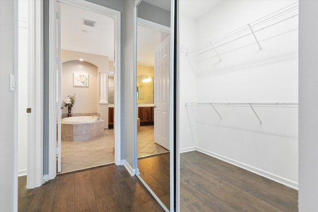 walk in closet with wood-type flooring