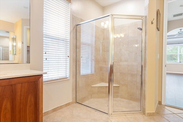 bathroom with a shower with door, vanity, and tile patterned floors