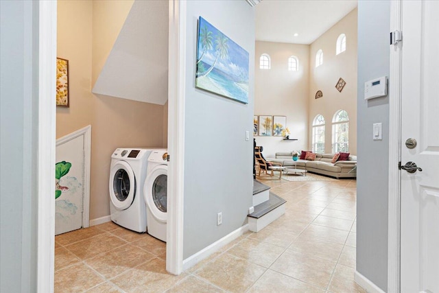 clothes washing area with washing machine and dryer and light tile patterned floors