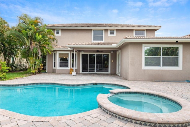 view of swimming pool with ceiling fan, a patio, and an in ground hot tub