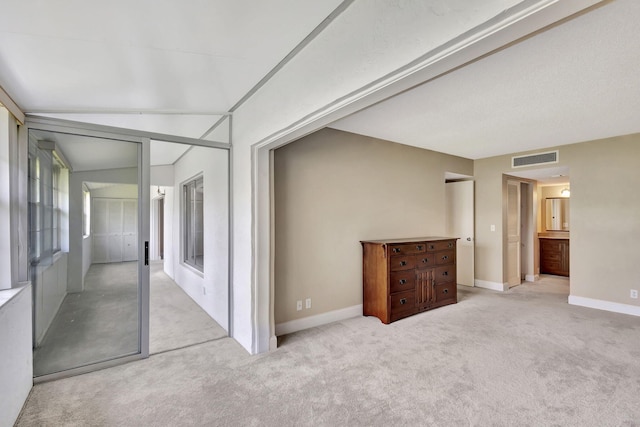 unfurnished room with light colored carpet and lofted ceiling