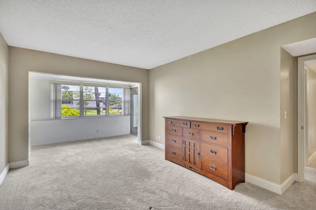 carpeted spare room featuring a textured ceiling