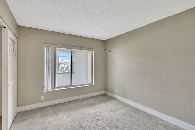 carpeted spare room with a textured ceiling