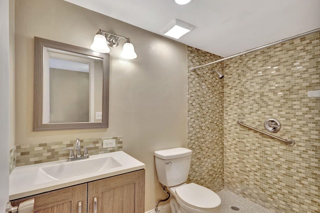 bathroom featuring decorative backsplash, a tile shower, vanity, and toilet