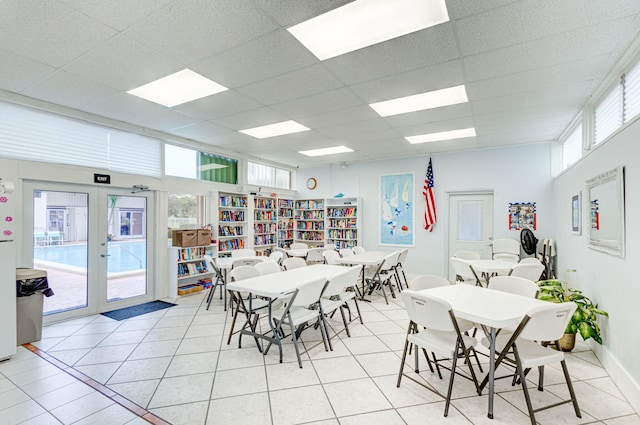 dining area with light tile patterned floors and a drop ceiling