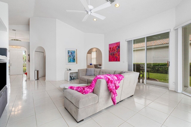 living room with a towering ceiling, ceiling fan, and light tile patterned floors