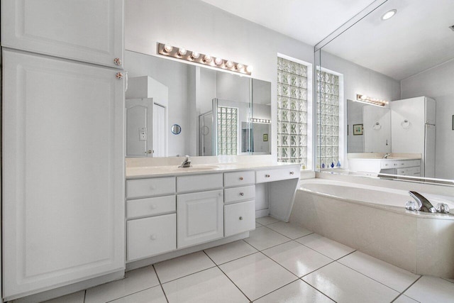 bathroom featuring a washtub, tile patterned flooring, and vanity