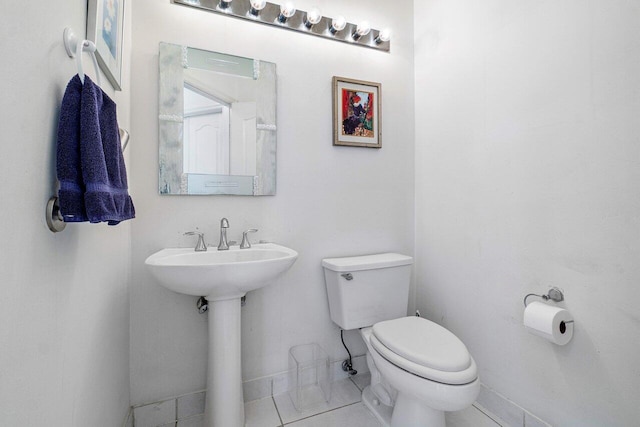 bathroom with toilet, tile patterned flooring, and sink