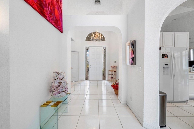 hallway featuring a chandelier and light tile patterned floors