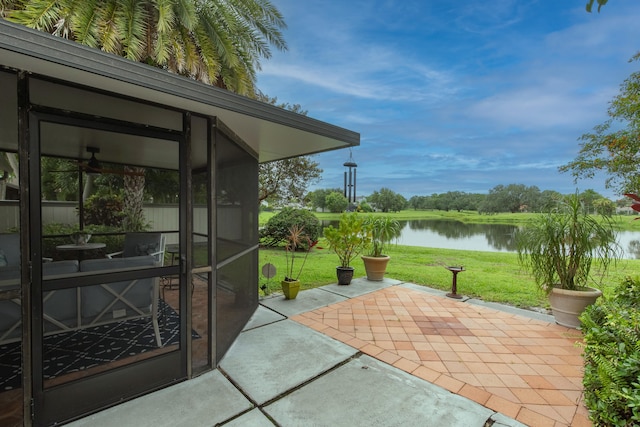 view of patio with a water view and a sunroom