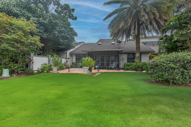 back of property featuring a patio, a sunroom, and a lawn