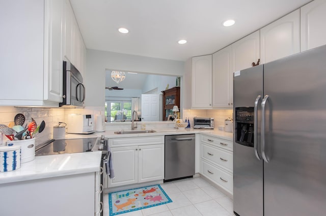 kitchen featuring backsplash, stainless steel appliances, sink, and white cabinets