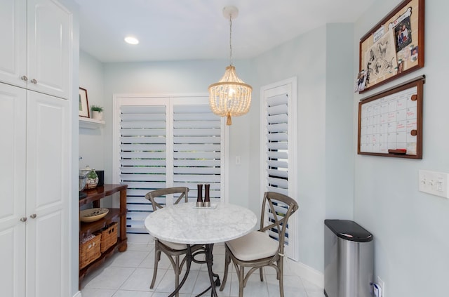 tiled dining room with a chandelier