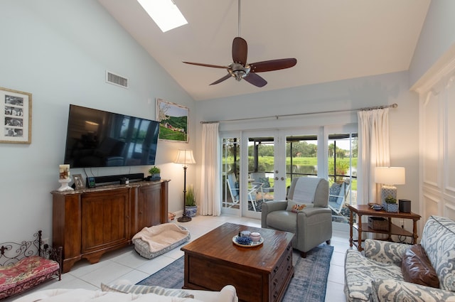 living room with ceiling fan, a skylight, high vaulted ceiling, light tile patterned flooring, and french doors