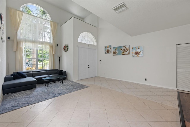 tiled entrance foyer featuring a wealth of natural light and a high ceiling