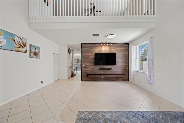 unfurnished living room with a high ceiling and light tile patterned floors