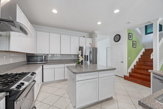 kitchen featuring a kitchen island, decorative backsplash, stainless steel appliances, and white cabinets