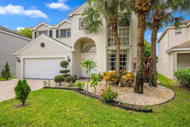 mediterranean / spanish-style home with a garage and a front lawn