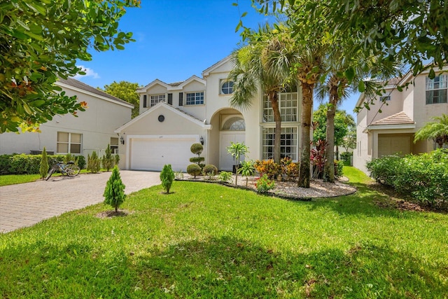 mediterranean / spanish-style home featuring a garage and a front lawn