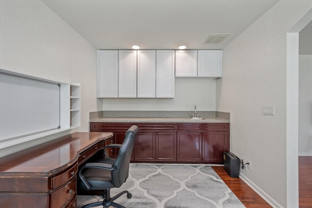 office space with sink, hardwood / wood-style floors, and built in desk