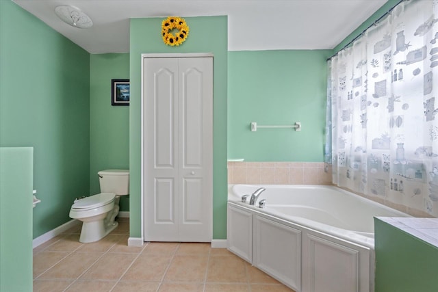 bathroom with tile patterned floors, a washtub, and toilet