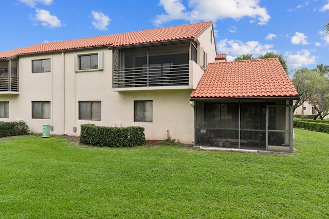 rear view of property with a sunroom, a yard, and central air condition unit