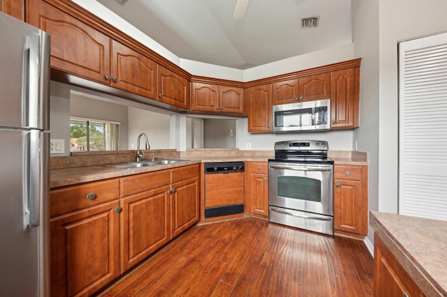 kitchen with appliances with stainless steel finishes, lofted ceiling, dark hardwood / wood-style flooring, sink, and ceiling fan