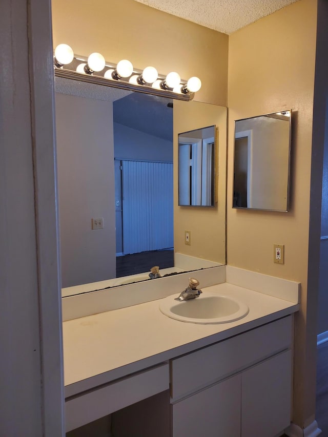 bathroom featuring a textured ceiling and vanity