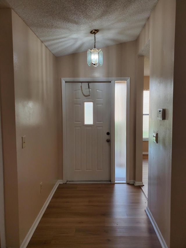 foyer entrance with hardwood / wood-style flooring and a notable chandelier