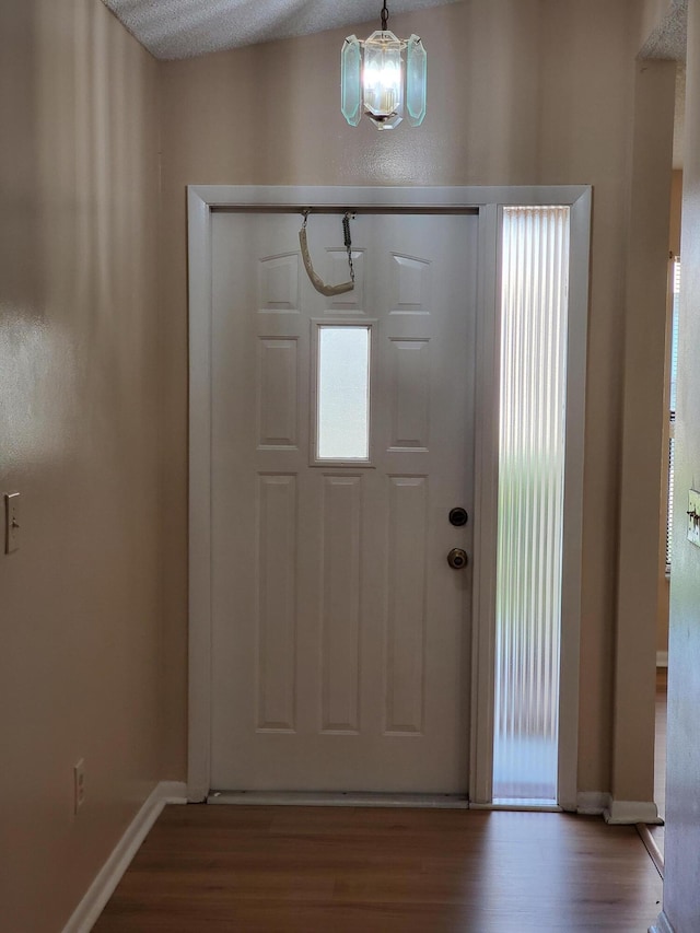 entrance foyer featuring a textured ceiling, an inviting chandelier, and wood-type flooring