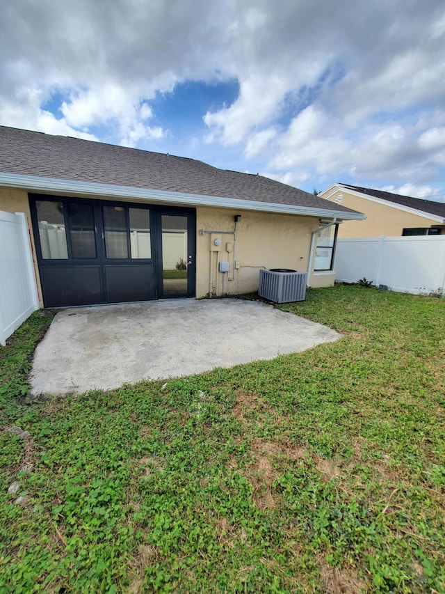 rear view of house featuring central AC, a patio area, and a yard