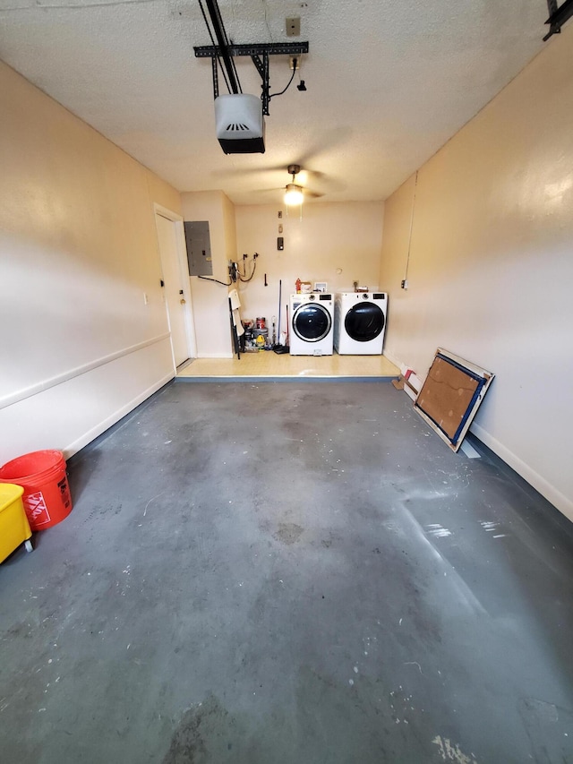 garage featuring a garage door opener, washing machine and clothes dryer, and electric panel