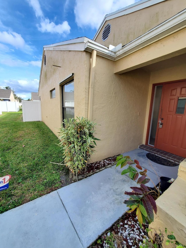 doorway to property featuring a patio area and a yard