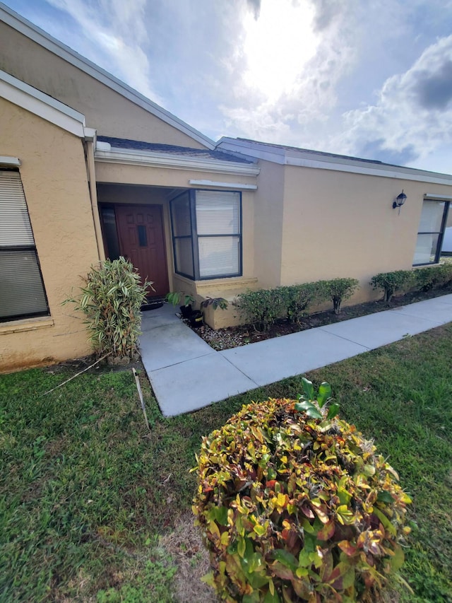 view of exterior entry featuring a yard