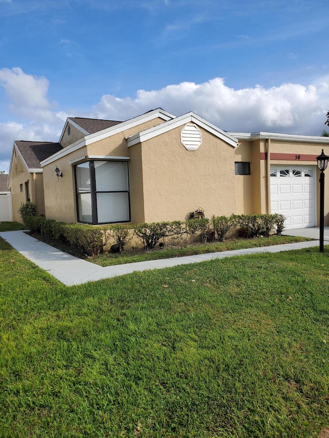 view of front of property featuring a front lawn and a garage