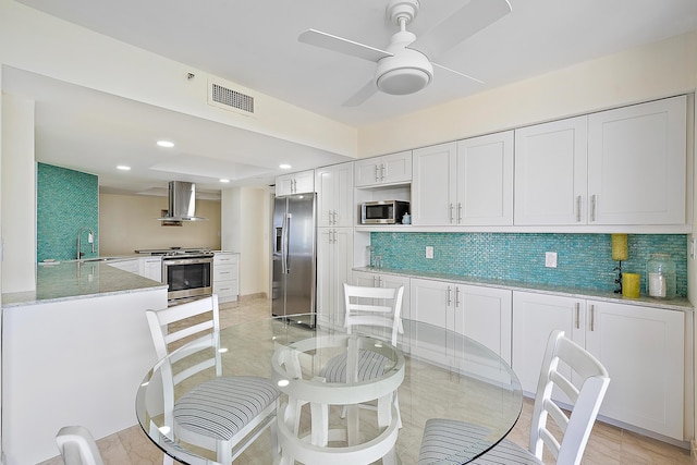 kitchen with white cabinetry, stainless steel appliances, kitchen peninsula, ceiling fan, and range hood