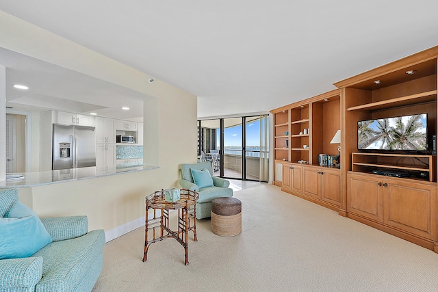 sitting room with light carpet and floor to ceiling windows