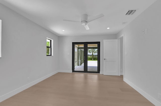 unfurnished room featuring light wood-type flooring, french doors, and plenty of natural light