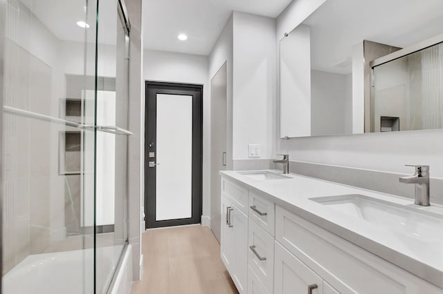 bathroom featuring shower / bath combination with glass door, vanity, and wood-type flooring